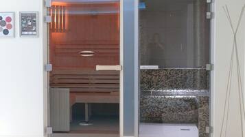 Un baño moderno con cabina de ducha de vidrio, tocador de madera y zona de ducha con azulejos.