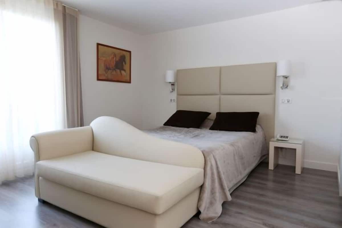 Une chambre à coucher avec un lit, une table de chevet, une lampe et un tableau au mur.