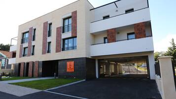 A modern hotel with a flat roof, large windows, and a parking garage.