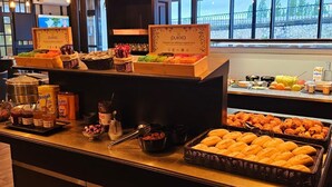 A buffet counter with various food items and condiments. - Hôtel Bellevue (Amboise)