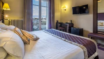 Une chambre d’hôtel avec un grand lit, un bureau, une chaise, une télévision et une vue sur l’extérieur.