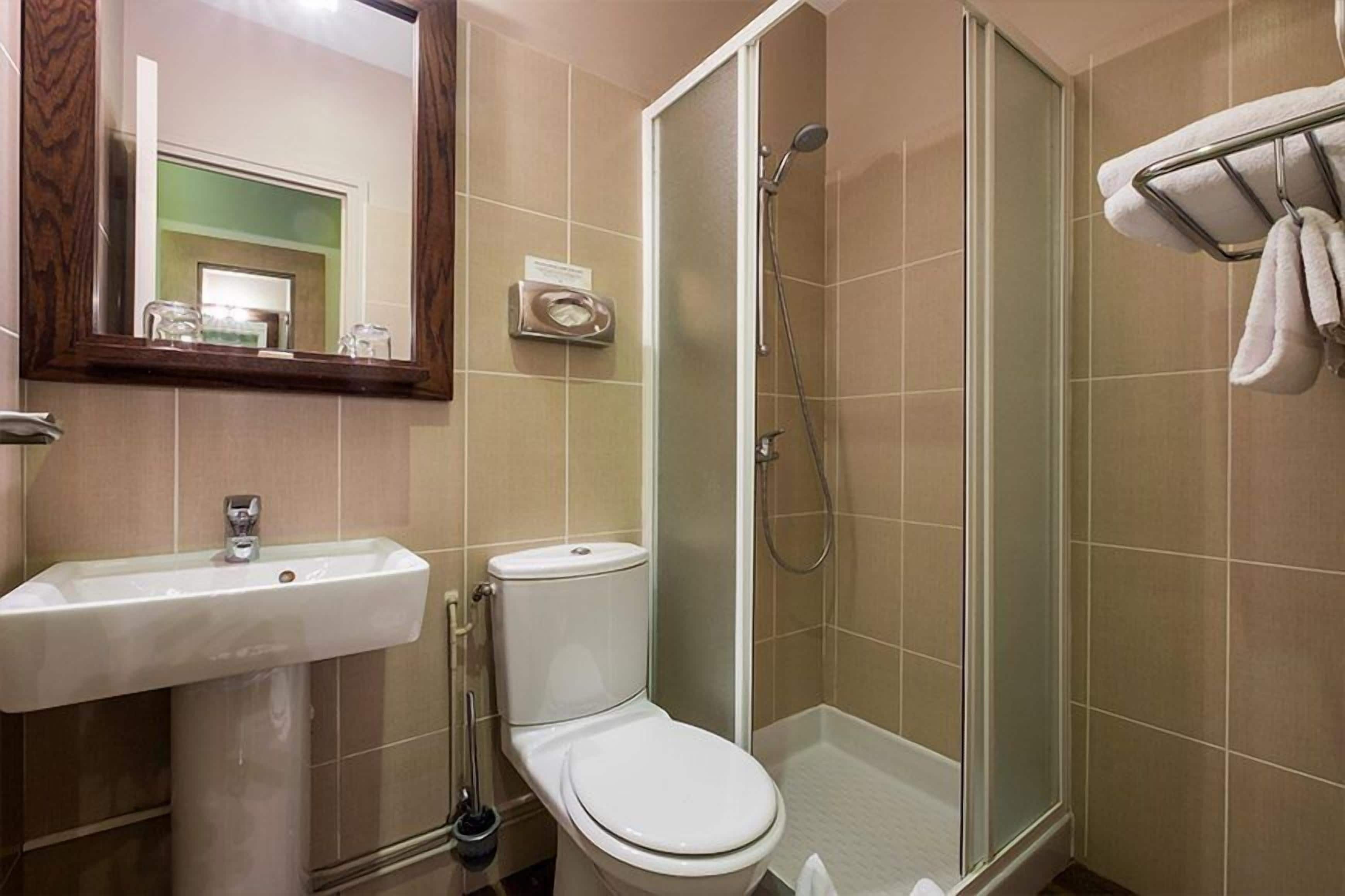 Un baño con lavamanos, inodoro y ducha.