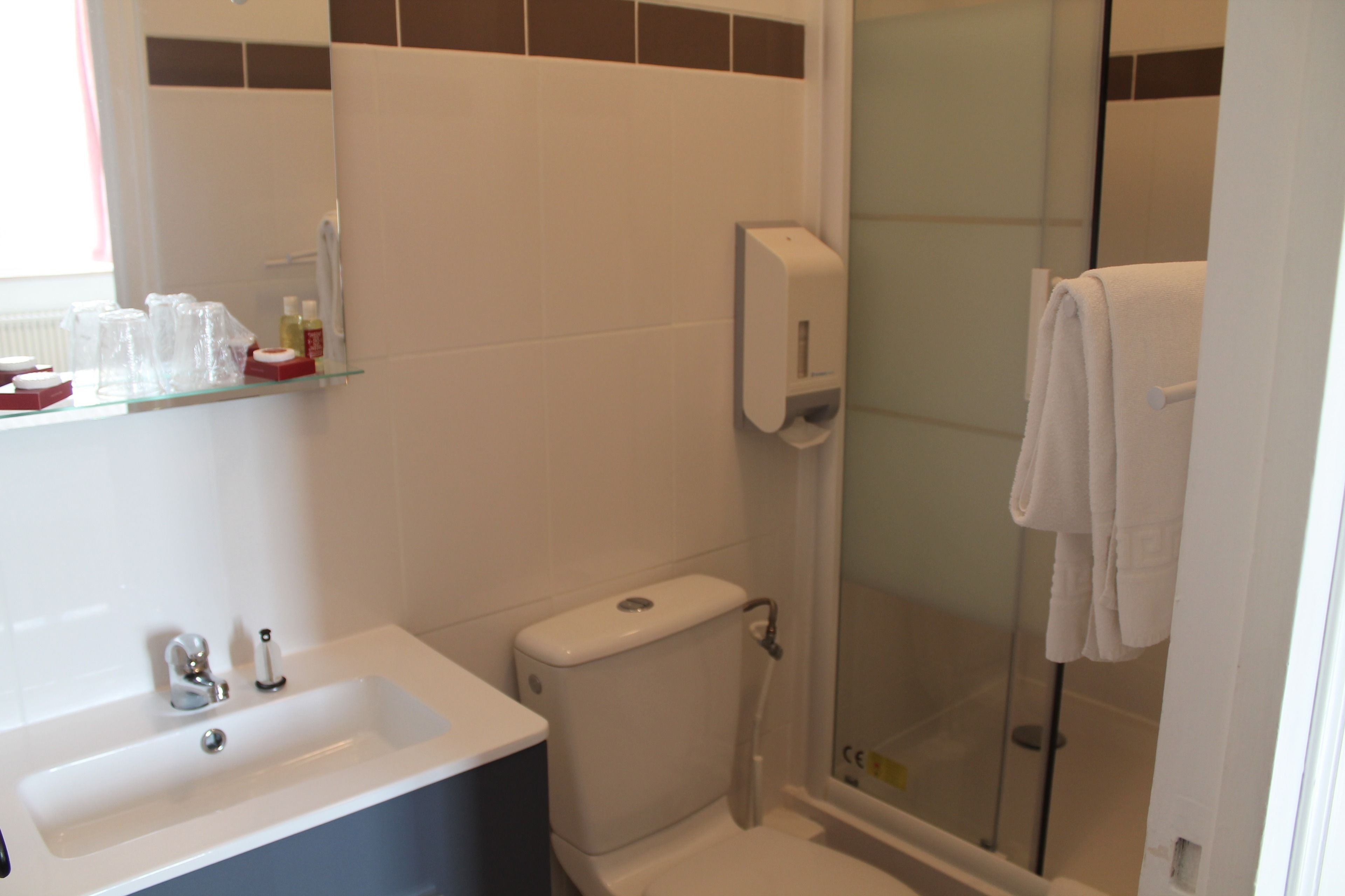 Un baño con lavamanos, inodoro y cabina de ducha de vidrio.
