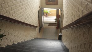 A staircase with a textured wall and a painting above. - Somatel Hotel (Douala)