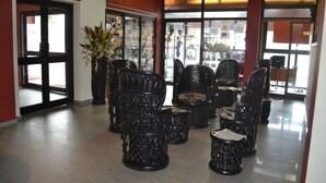 A lobby with several intricately designed chairs and a large potted plant. - Planet Hotel (Douala)