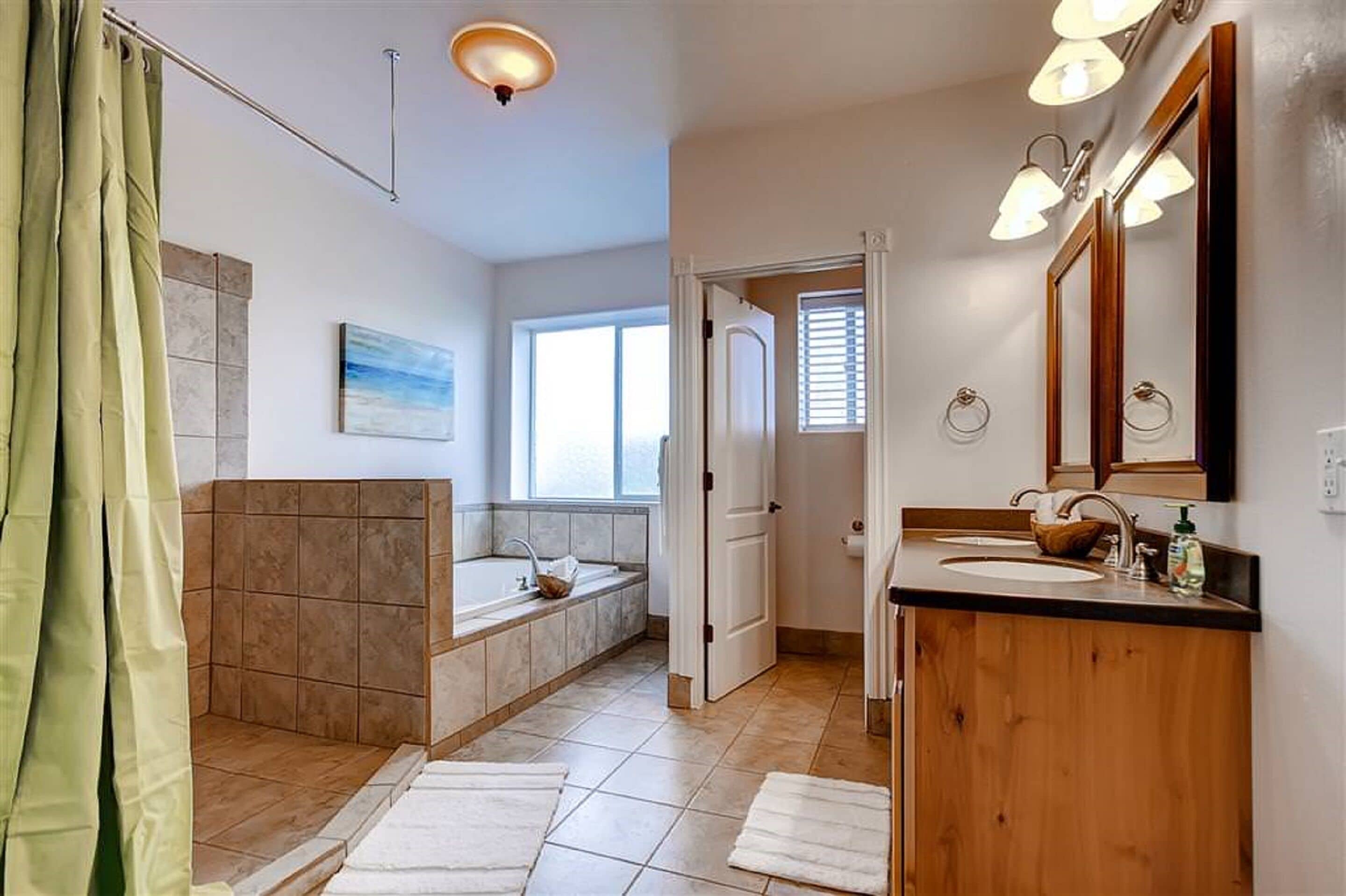 Een badkamer met een bad, een wastafel en een spiegel.