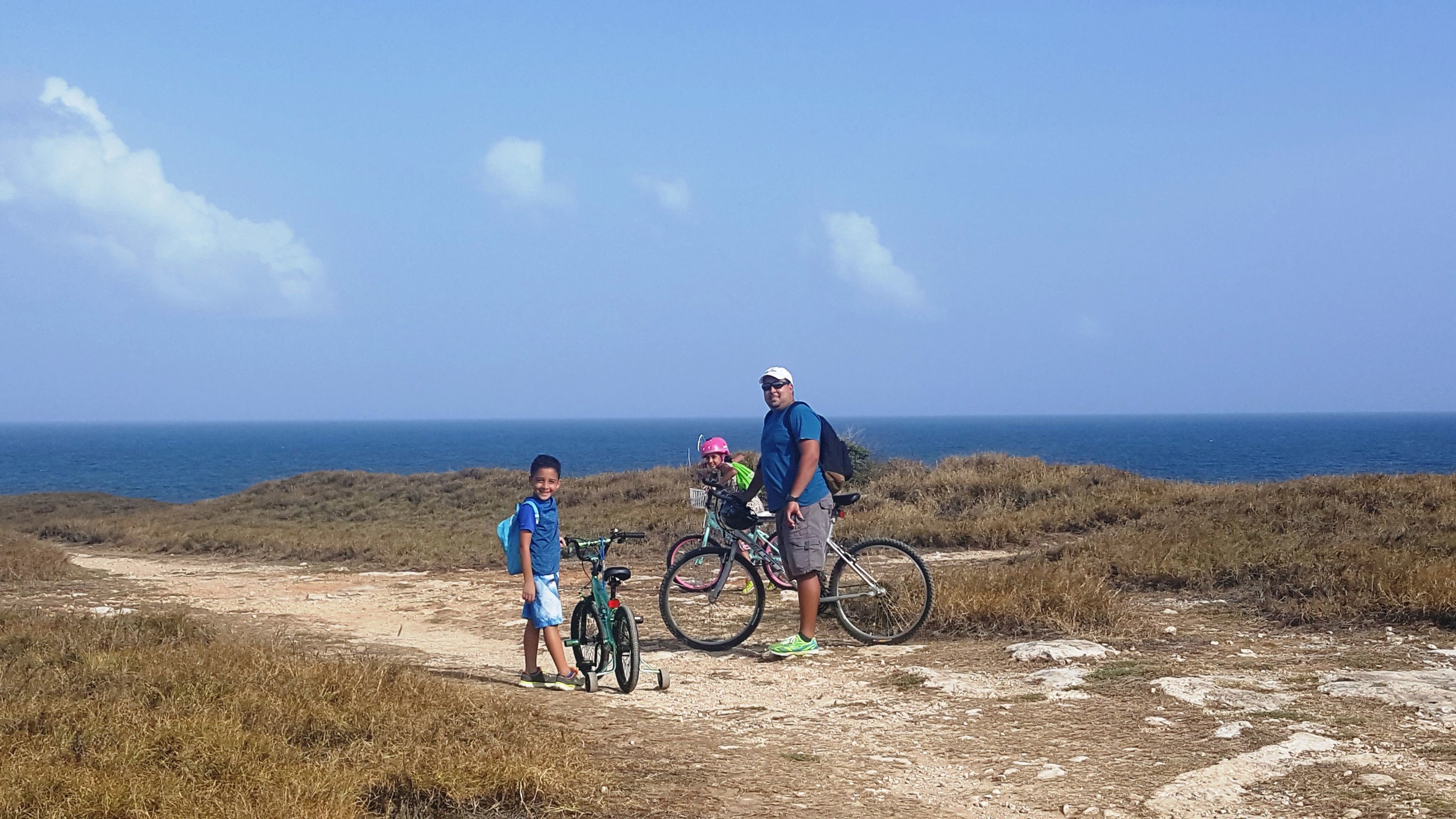 Un sentier côtier avec des vélos et une personne debout.
