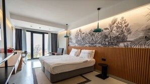 Un dormitorio moderno con una cama grande, un escritorio y vistas al exterior.
