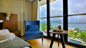 A hotel room with a large window offering a view of a bridge and cityscape. - Zimmer Bosphorus Hotel - Special Class (Istanbul)