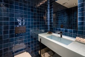 A modern bathroom with dark blue tiles, a white sink, and a large mirror. - Zimmer Bosphorus Hotel - Special Class (Istanbul)
