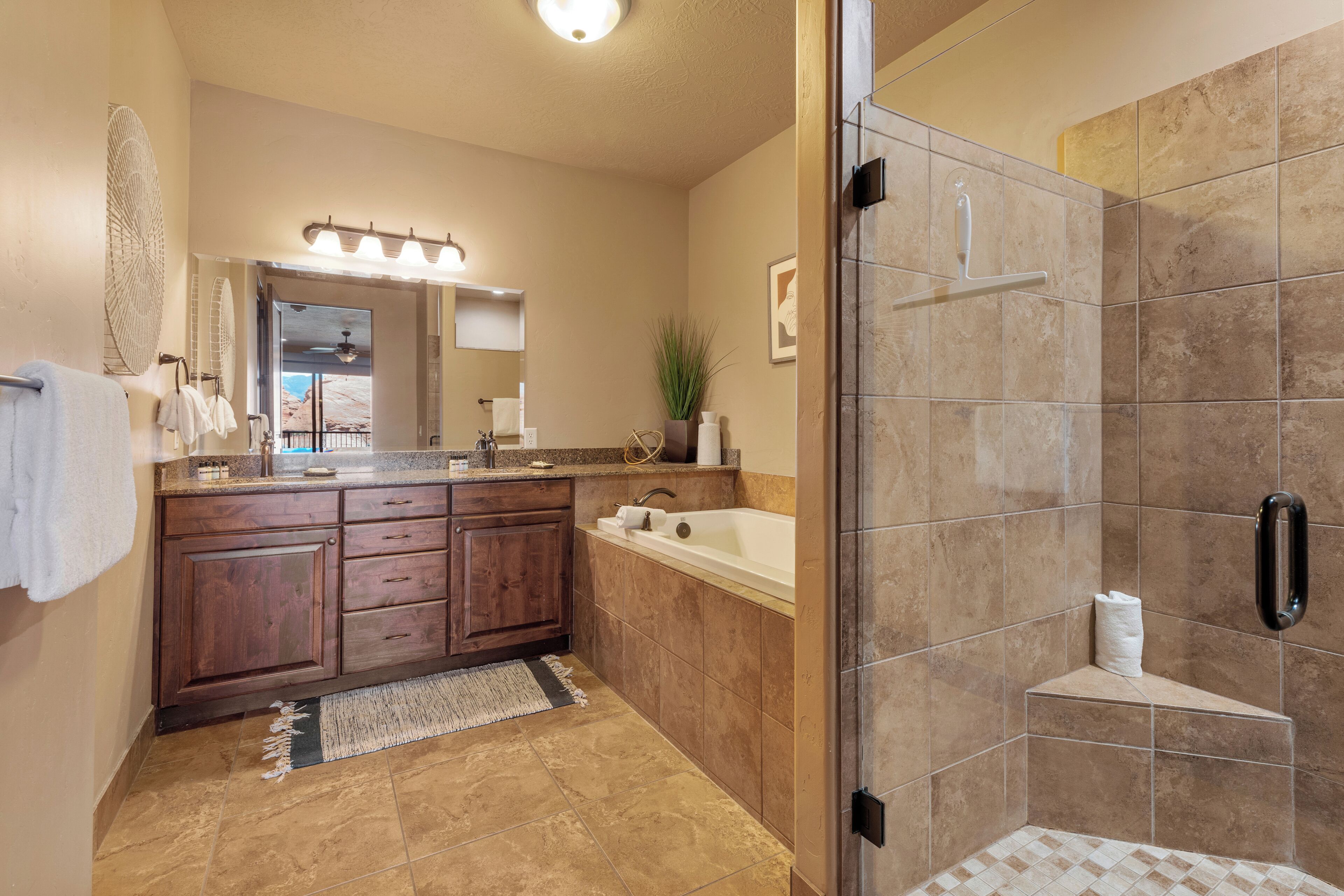 A modern bathroom with a large mirror, a bathtub, and a walk-in shower.