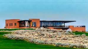 A modern house with a flat roof, large windows, and a balcony. - Vacation Rentals at Sand Hollow Resort (Hurricane)