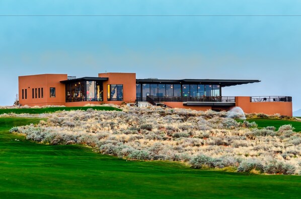 A modern house with a flat roof, large windows, and a balcony.