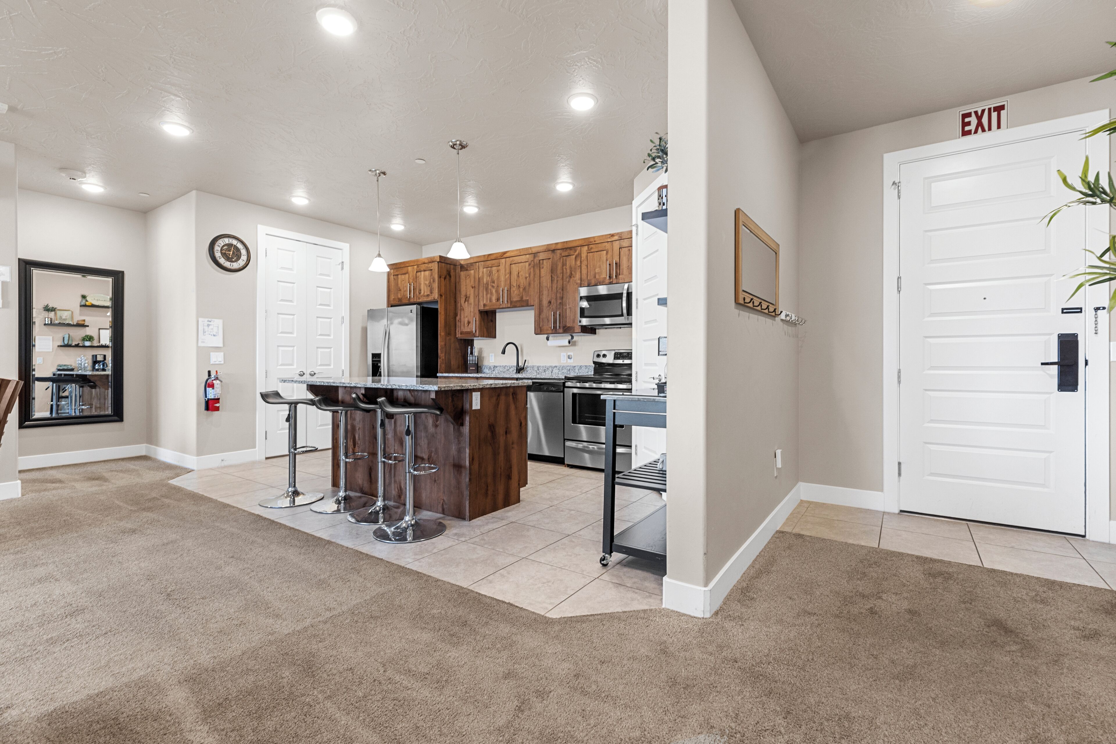 A spacious kitchen with wooden cabinets, stainless steel appliances, and a central island with bar stools.