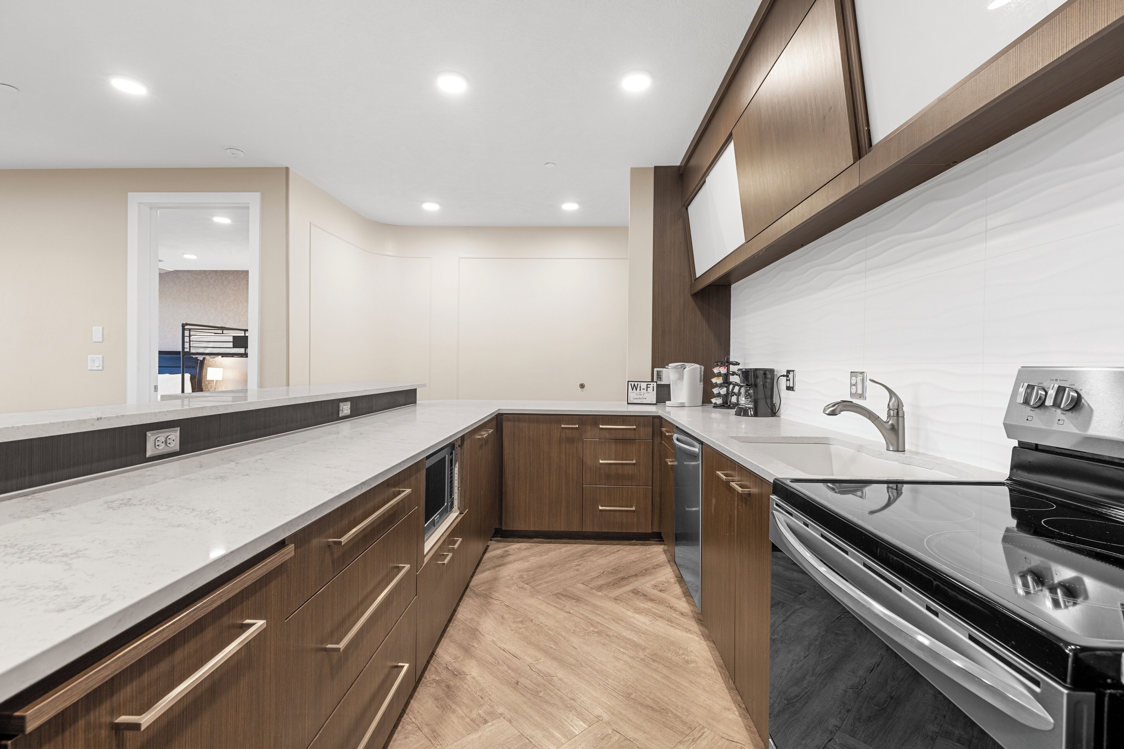 A modern kitchen with wooden cabinets, a stainless steel stove, and a marble countertop.