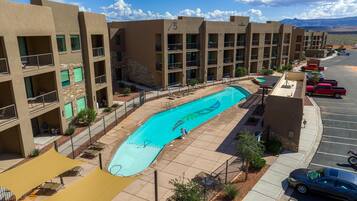 Enjoy a refreshing swim in the central courtyard pool surrounded by lounge chairs and a shaded seating area.
