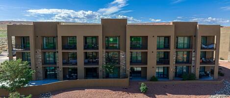 A multi-story hotel with a desert landscape in the background.