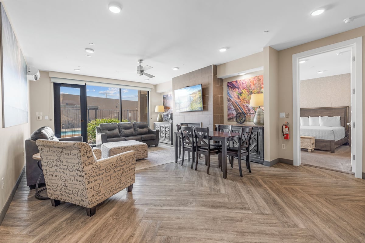 A spacious living area with a dining table, sofas, and a fireplace.