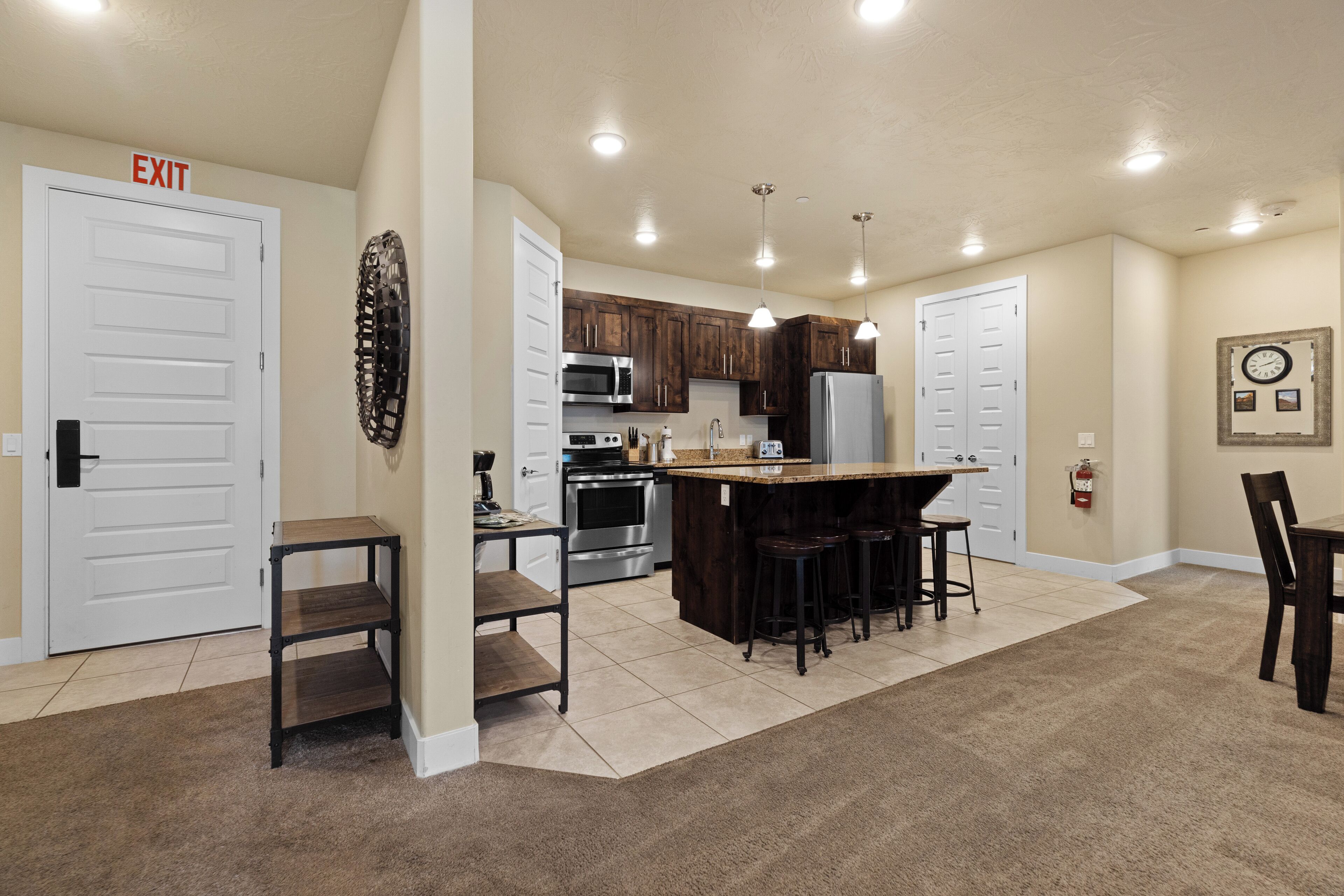 A modern kitchen with a central island, built-in appliances, and a dining area with a bar stool.