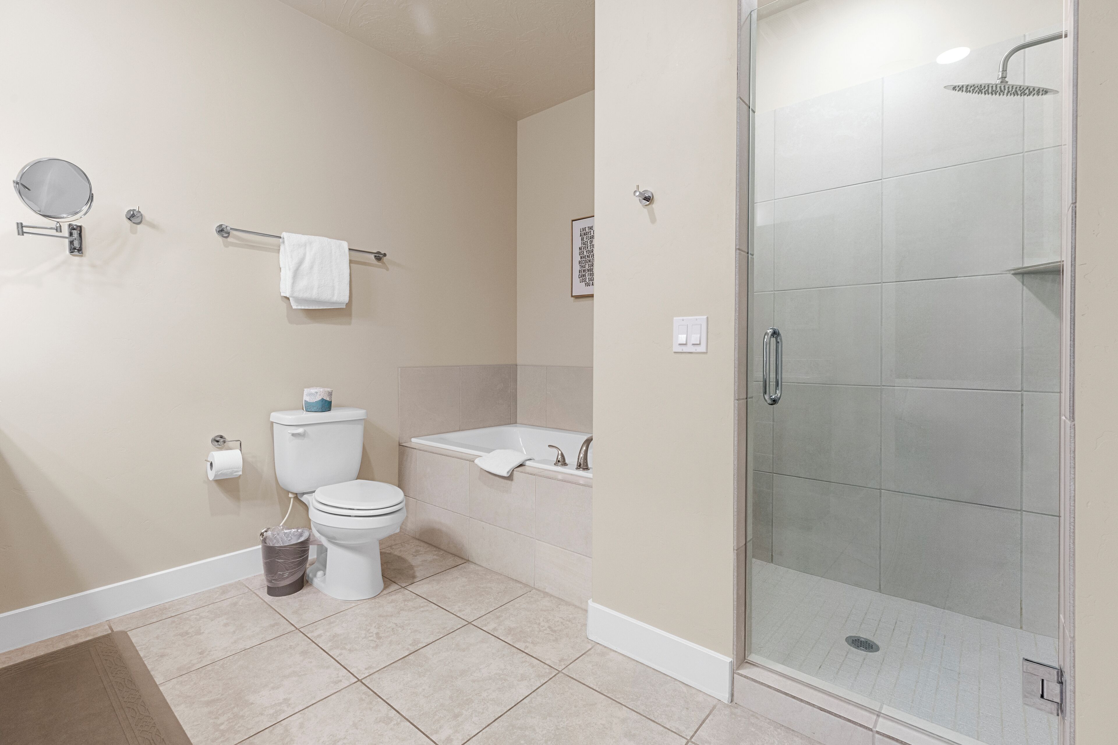 Un baño con inodoro, bidé y ducha con mampara de vidrio.