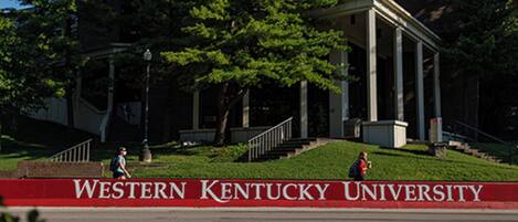 A building with a red banner reading "Western Kentucky University" and a staircase leading up to it.