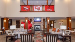 A spacious lobby with a fireplace, two sofas, and a large red sculpture. - Staybridge Suites Bowling Green by IHG (Bowling Green)