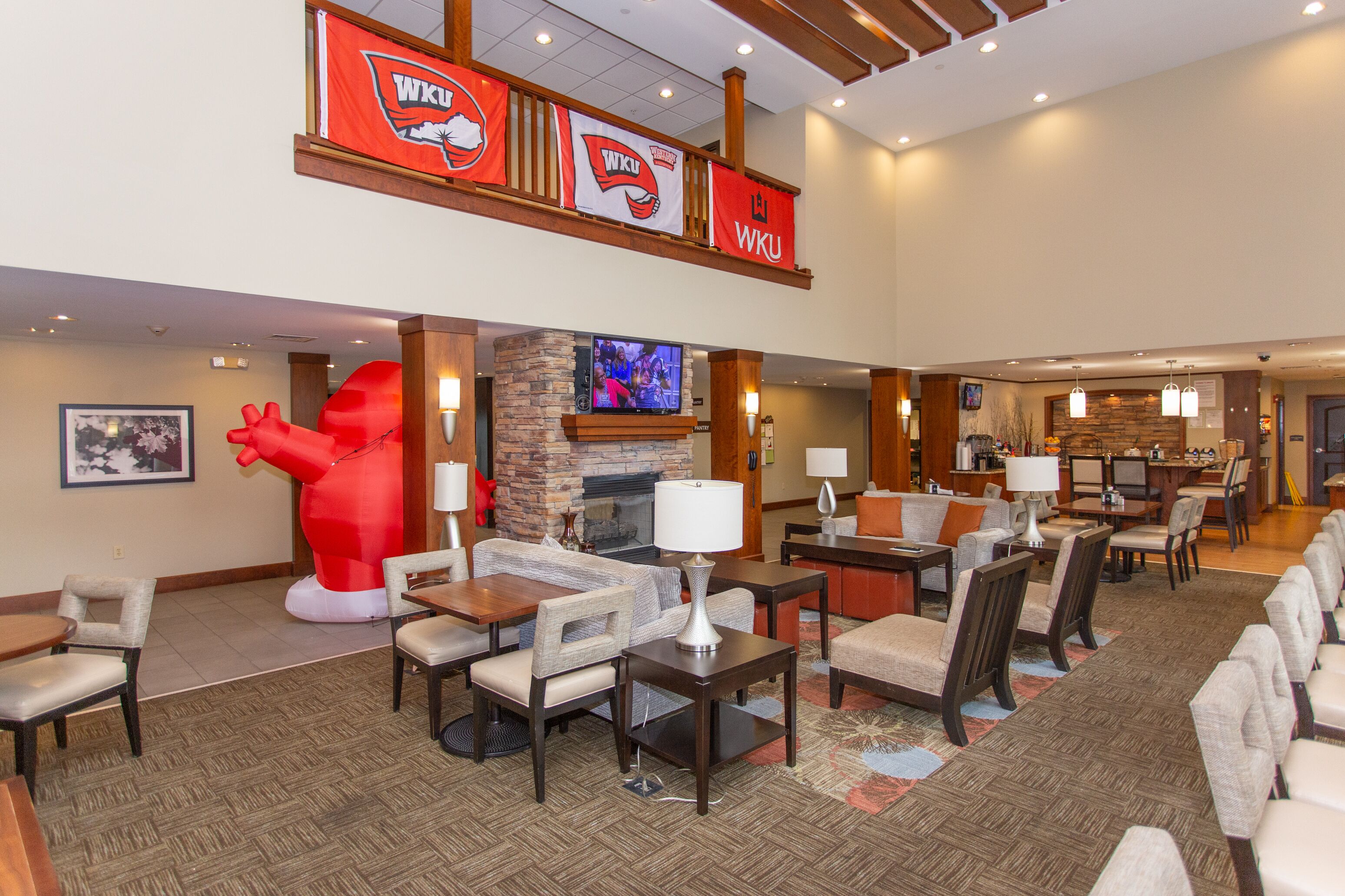 A hotel lobby with a fireplace, seating area, and a large red sculpture.