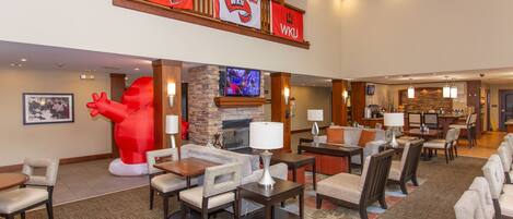 A hotel lobby with a fireplace, seating area, and a large red sculpture.