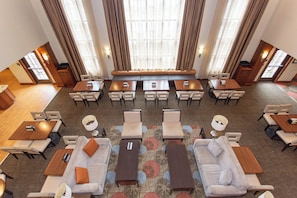 A hotel lobby with a central seating area, multiple tables, and chairs arranged for guests. - Staybridge Suites Bowling Green by IHG (Bowling Green)