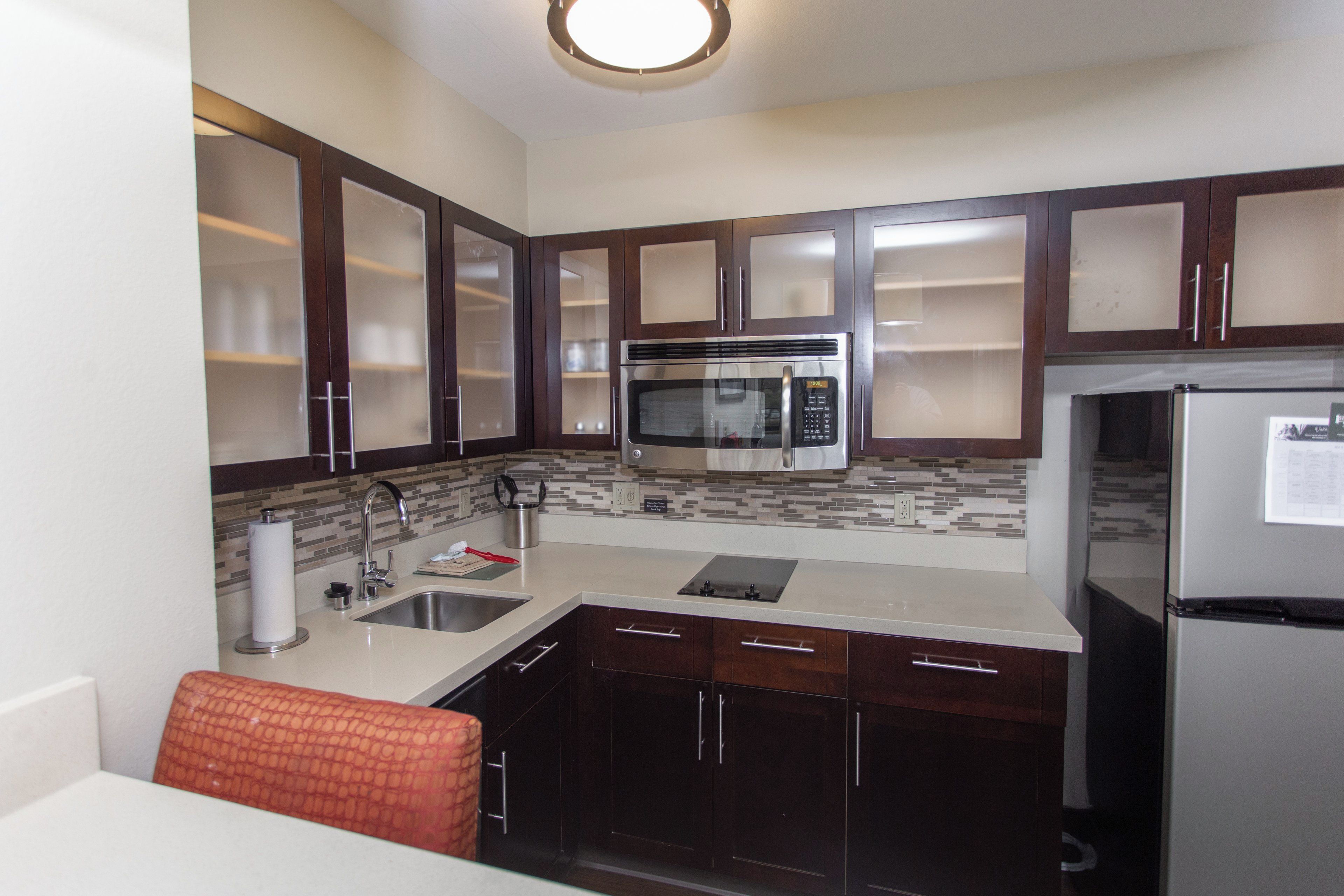 A modern kitchen with a stainless steel refrigerator, a microwave, and a sink.