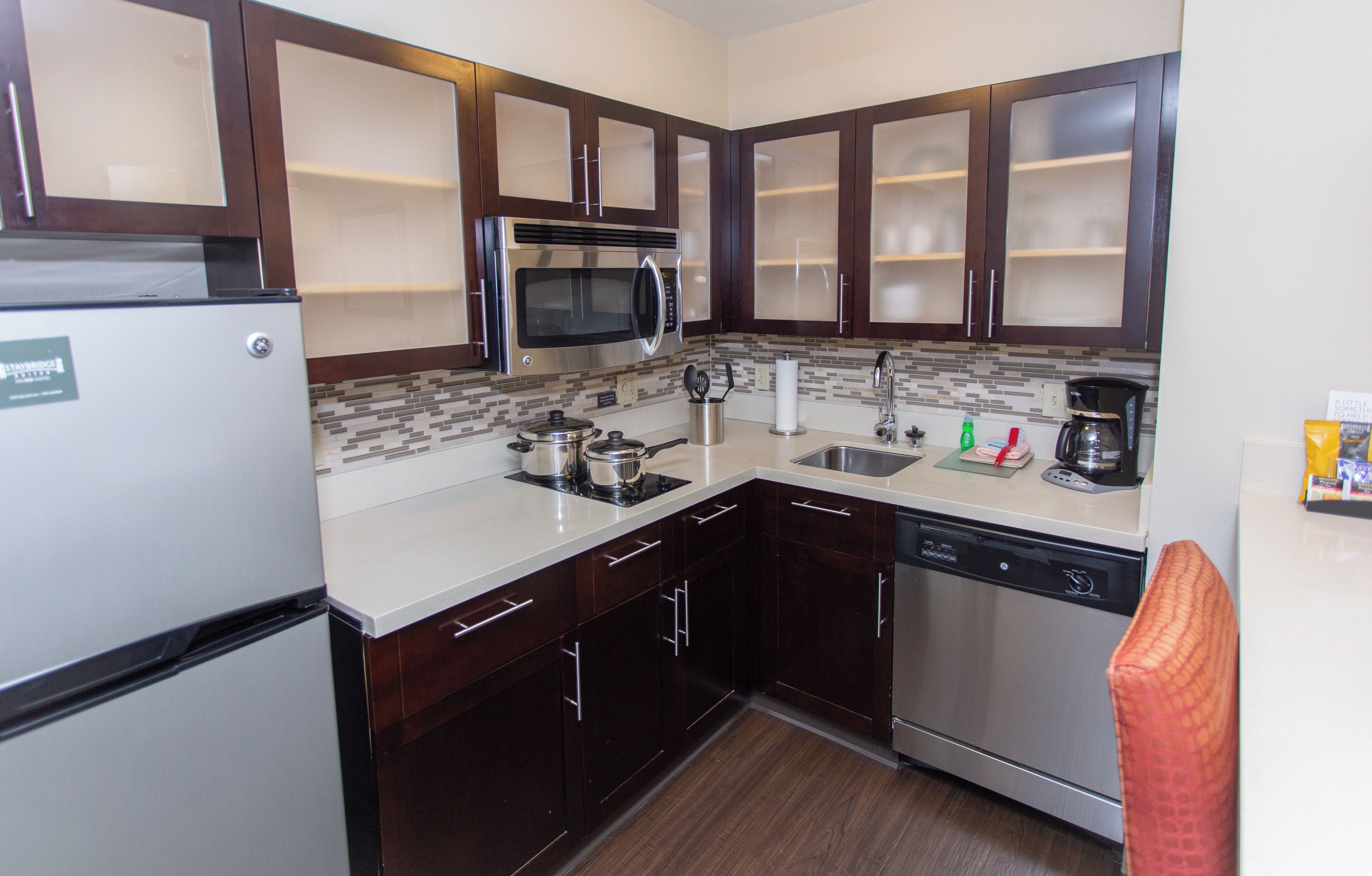 A compact kitchen with a refrigerator, microwave, stove, sink, and dishwasher.