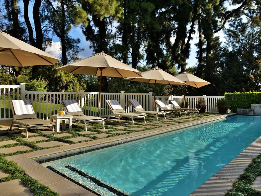 Een buitenzwembad, parasols voor strand/zwembad