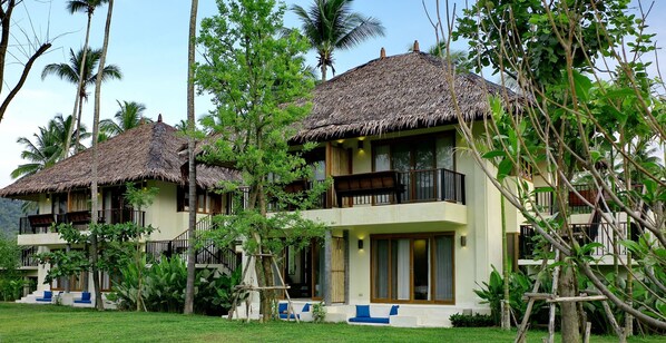 A resort with thatched-roof bungalows, a pool, and lush tropical vegetation. - Bangsak Village - Adults Only (Takua Pa)