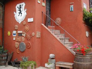 A staircase leading to a building with a red wall adorned with various sculptures and plaques. - Locanda del Principato (Castiglione del Lago)