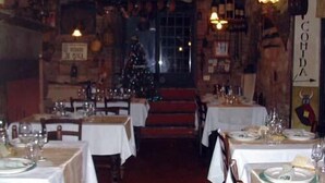 Un restaurante con mesas dispuestas para comer, un árbol de Navidad al fondo y un letrero que dice "COMIDA".