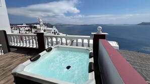 A hot tub on a balcony with a view of the sea and white buildings. - Maryloujohn Villas (Santorini)