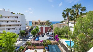 A residential area with a swimming pool, parked cars, and a view of the sea. - Hostal Residencia Sutimar (Calvia)