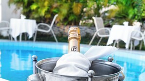 A champagne bottle in a metal bucket by a poolside. - Hotel Dolce Vita Resort (Bujumbura)