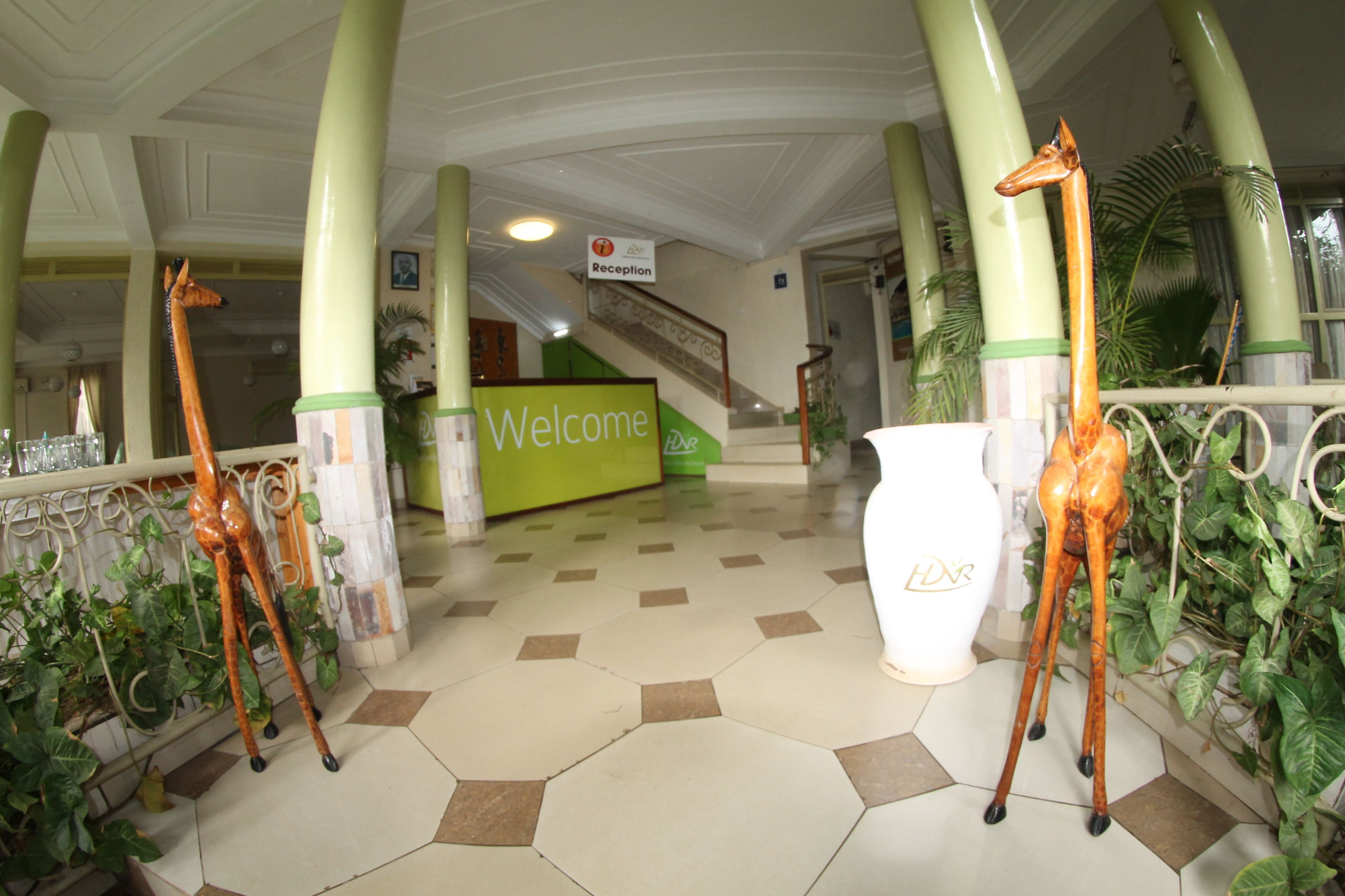 A reception area with a 'Welcome' sign, reception desk, and two giraffe statues.