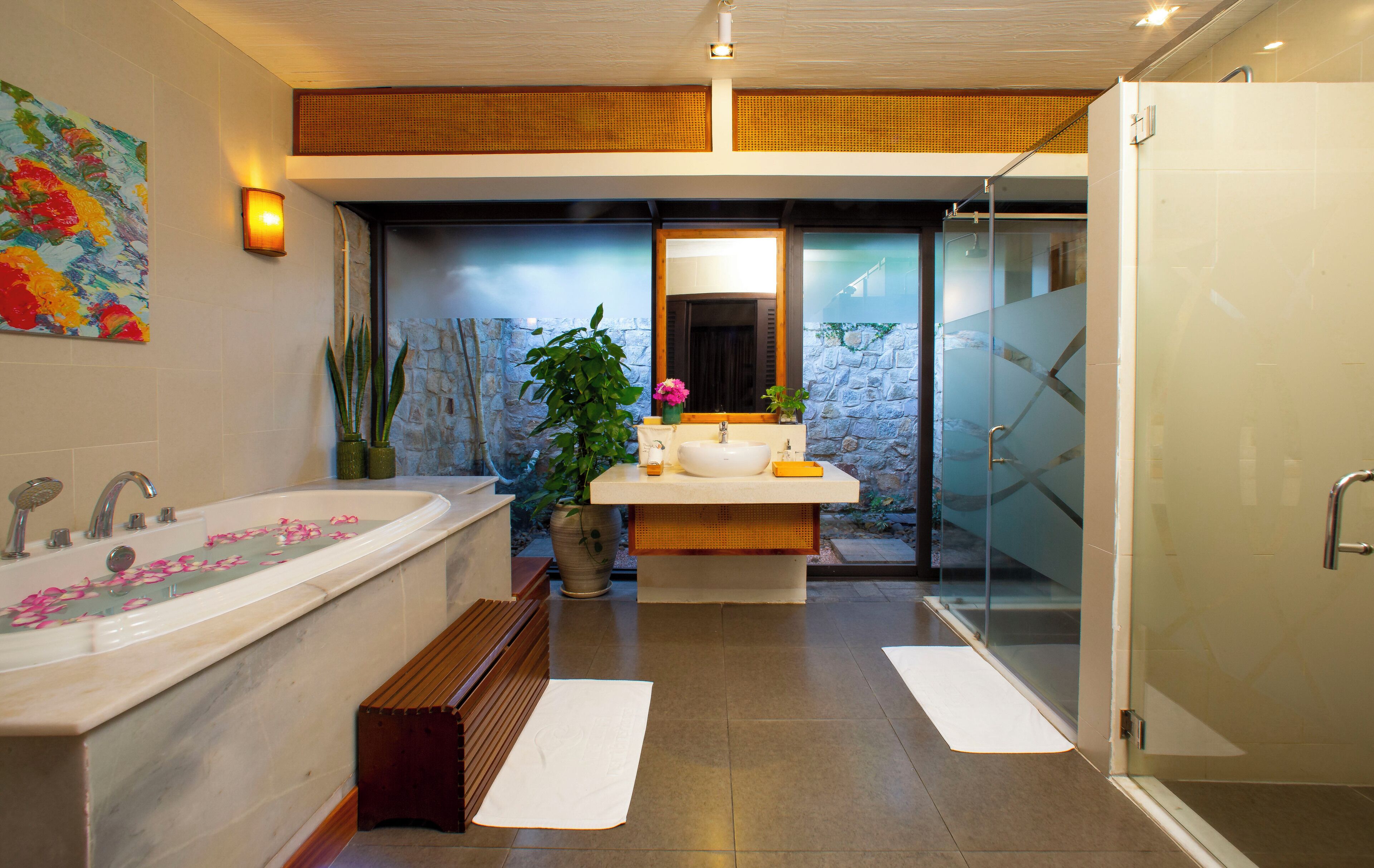 A modern bathroom with a large bathtub, a shower, and a vanity with a mirror.