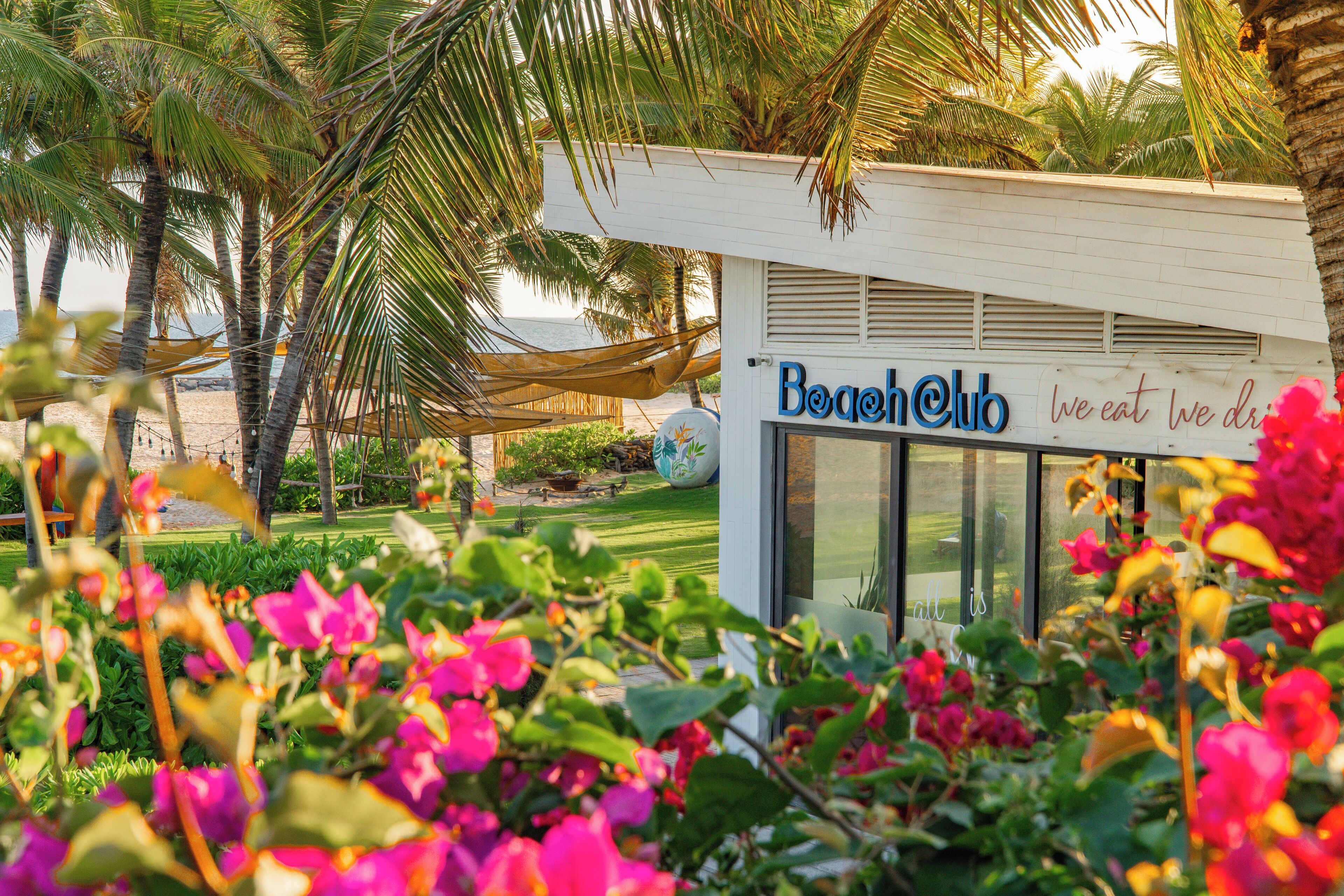 Un club de playa con un letrero que dice 'Beach Club we eat we drink'.