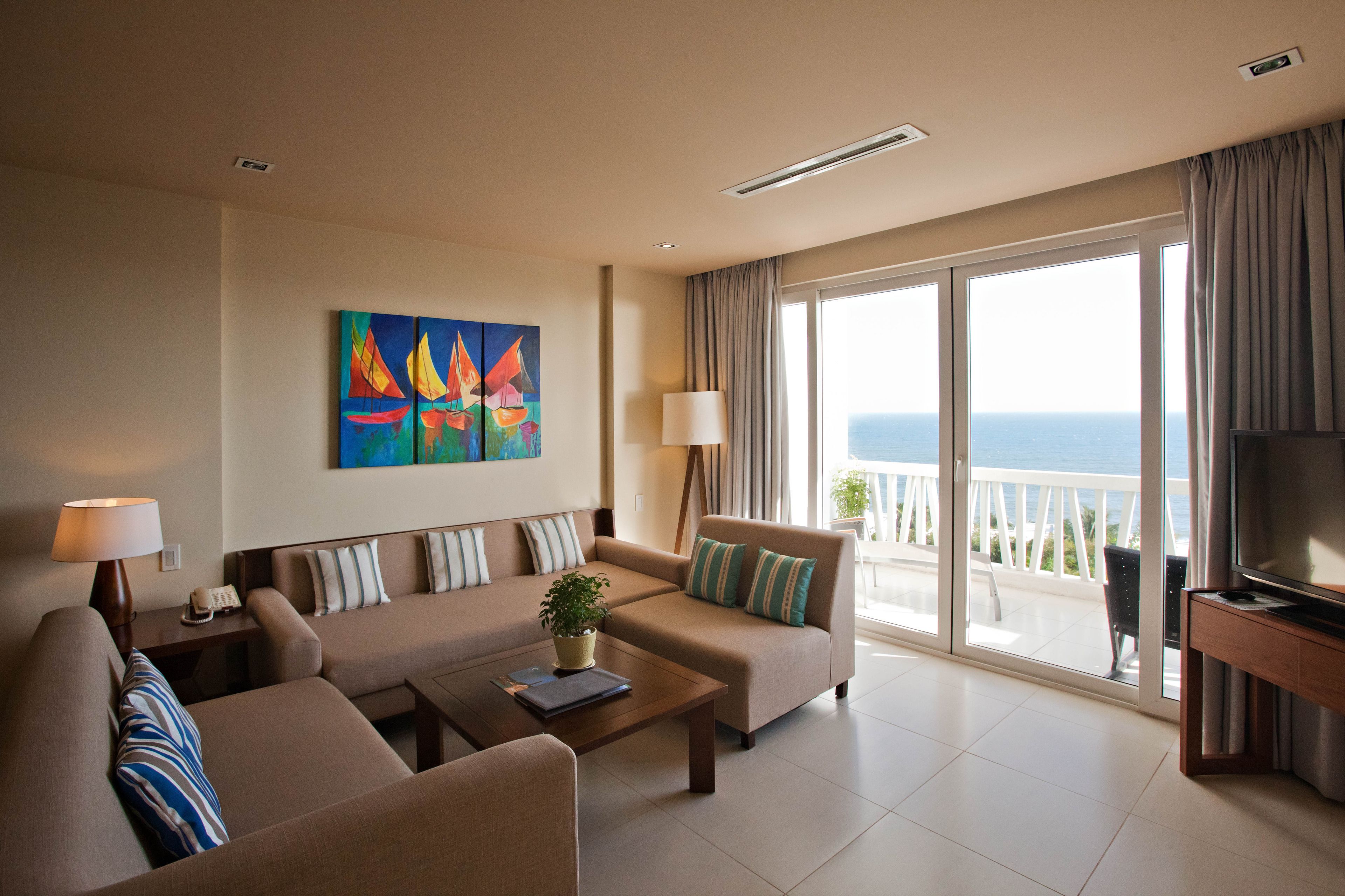 A modern living room with a sofa, a coffee table, a TV stand, and a painting on the wall.