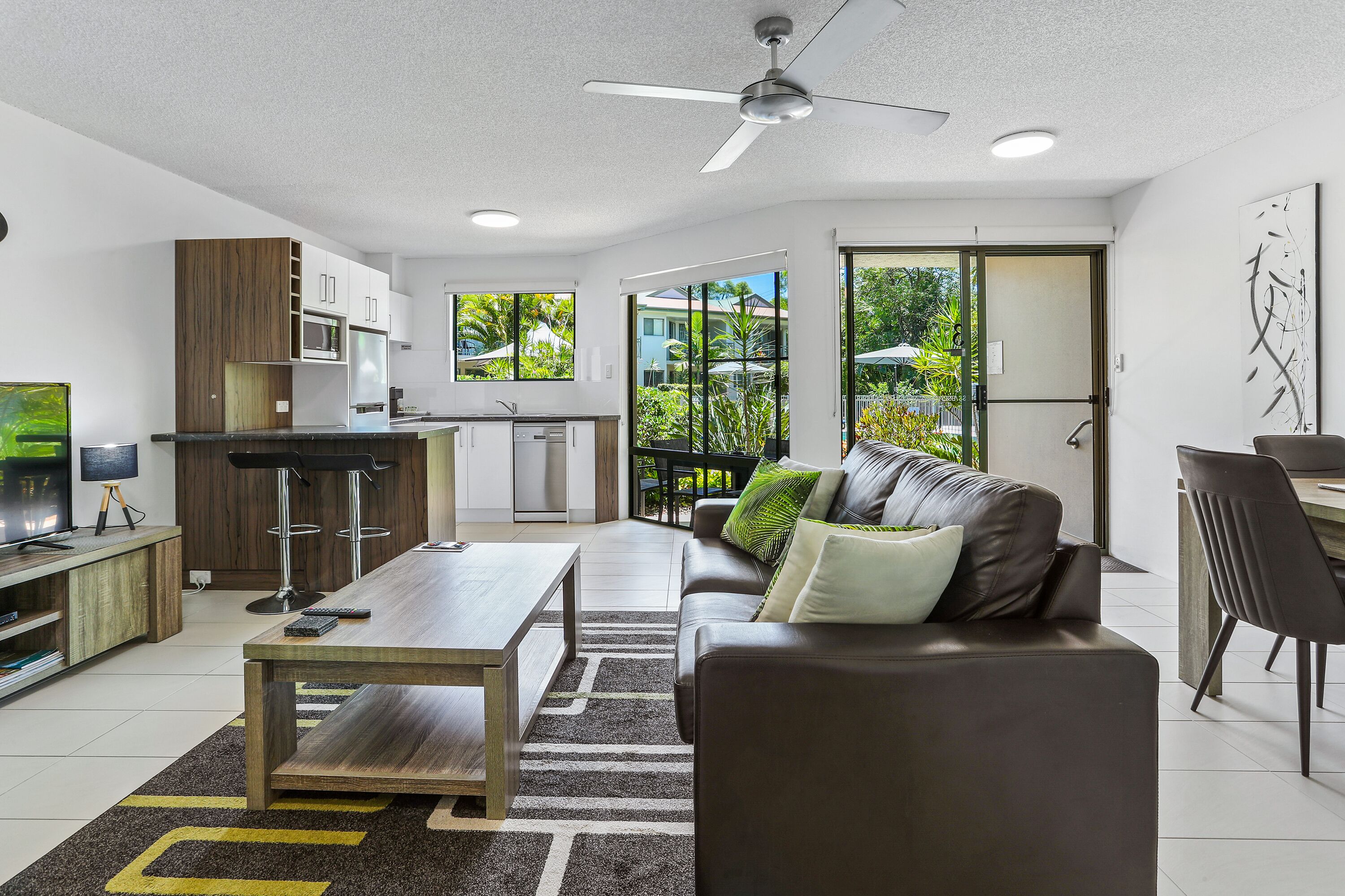 Un espacio habitable moderno con cocina, comedor y sofá con mesita de centro.