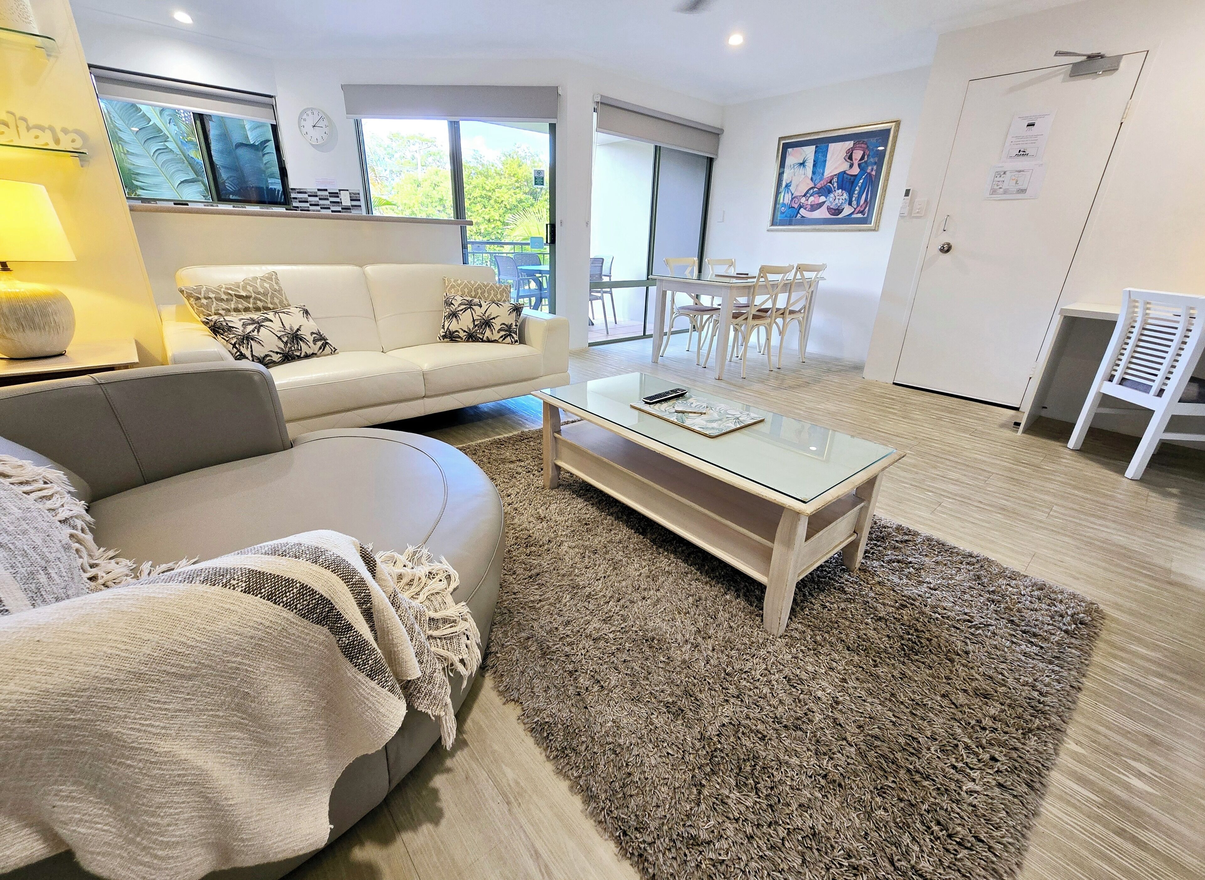 Un moderno salón con sofá, mesa de centro y vistas al exterior.