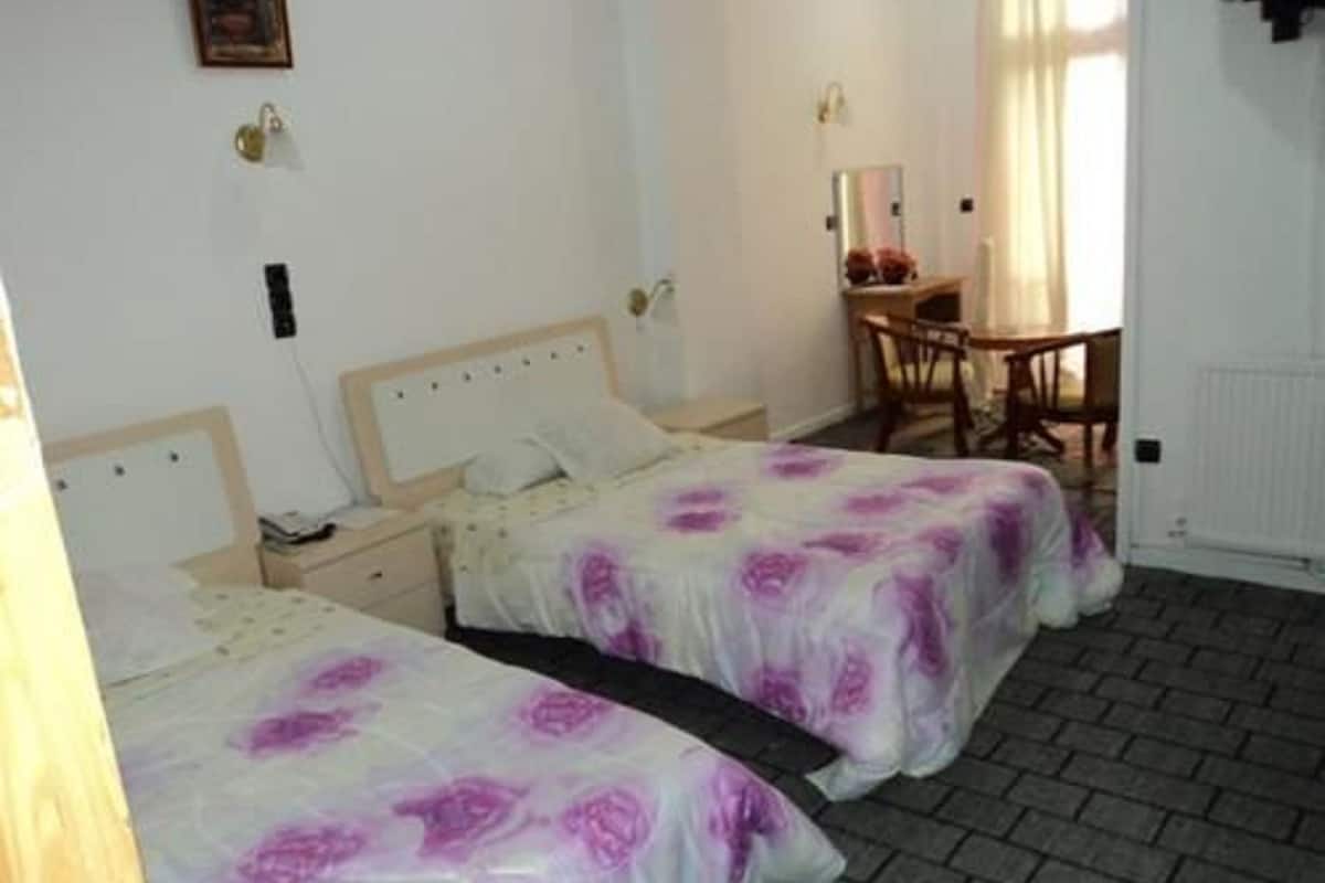 Una habitación de hotel con dos camas, un escritorio y una silla.