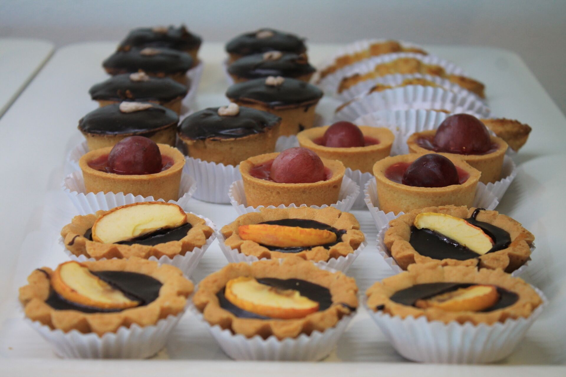 A variety of tartlets arranged on a tray.