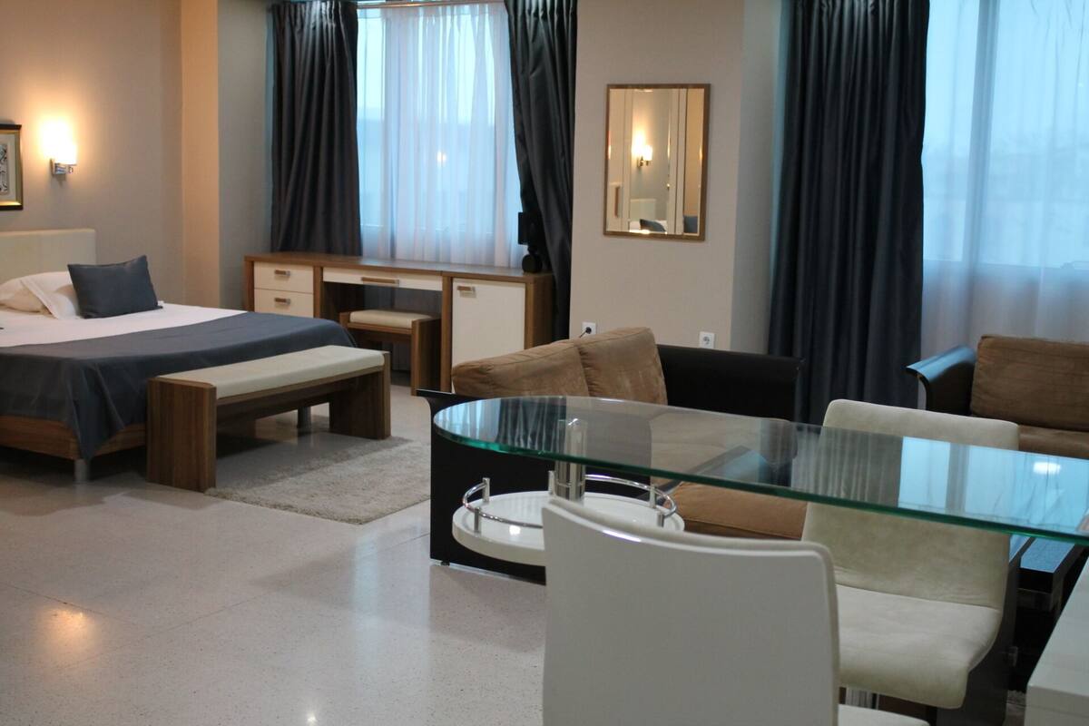 Una habitación de hotel moderna con cama, escritorio y zona de estar.