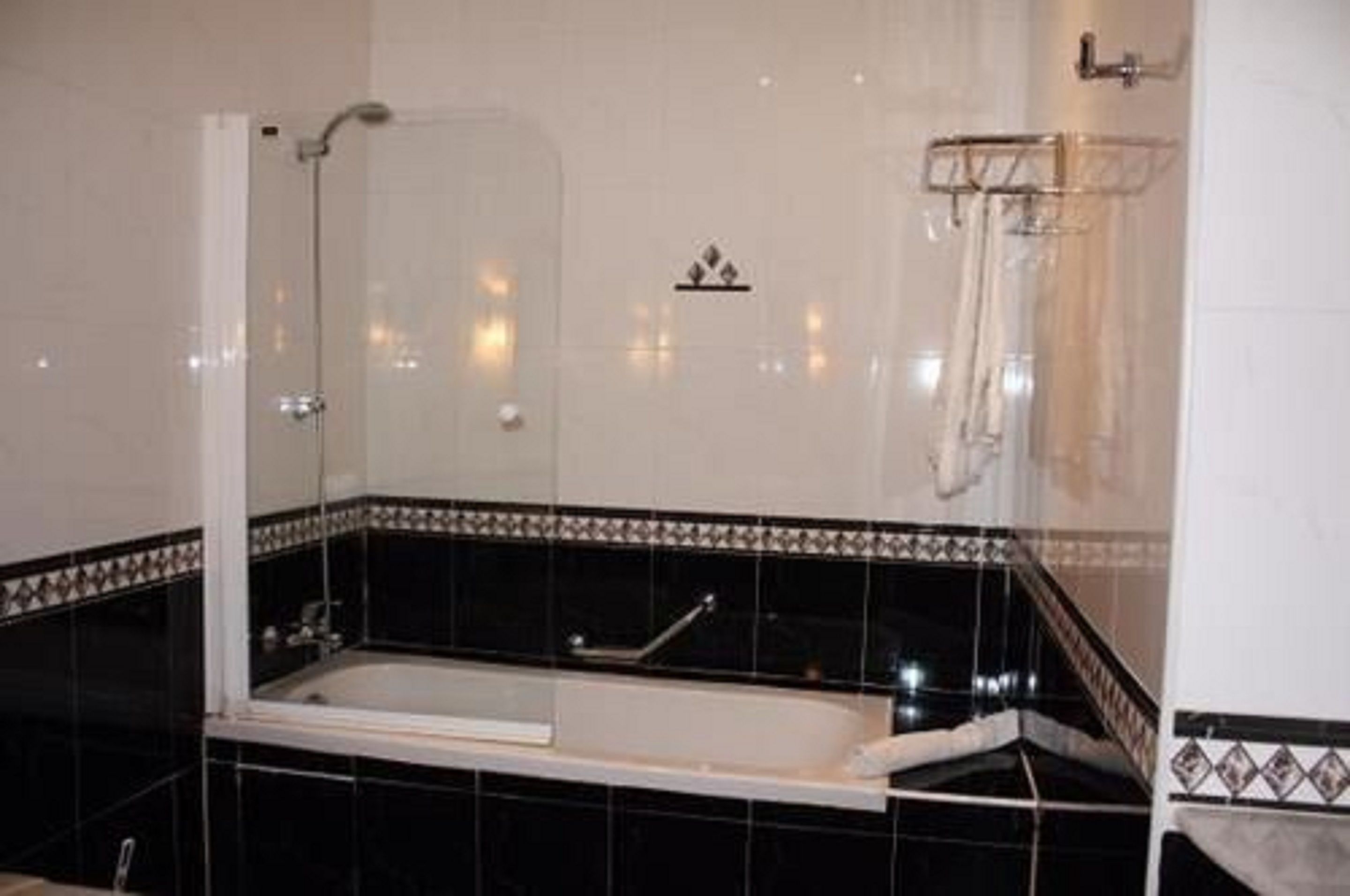 Ein Badezimmer mit einer Badewanne, einer Dusche und einem Handtuchhalter.
