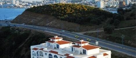 A coastal building with a prominent hill in the background.