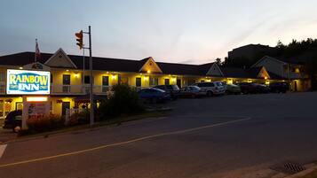 A motel with a sign reading "Rainbow Inn" and a parking lot with several cars.